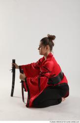 Woman Adult Average Fighting with knife Kneeling poses Coat Latino